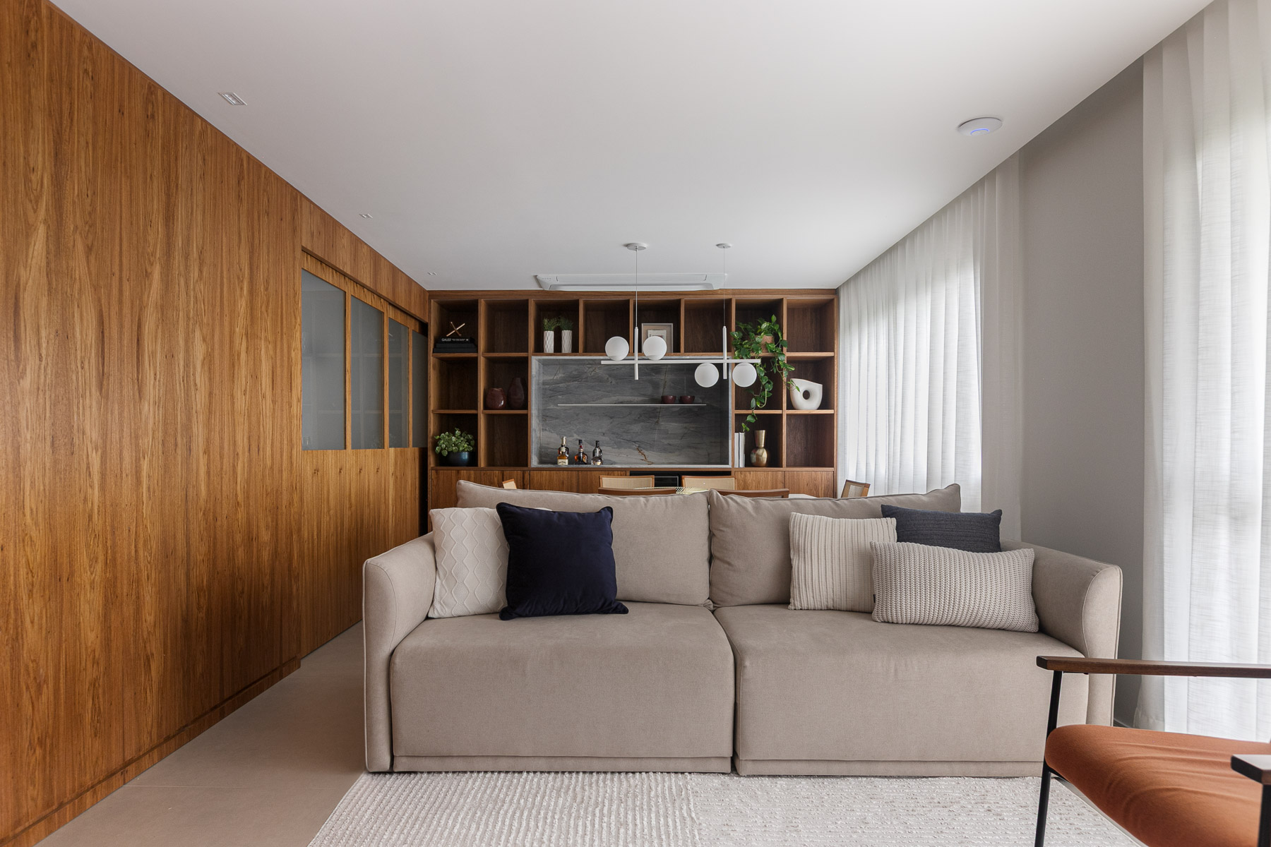 Sala de estar integrada com sofa e estante em madeira