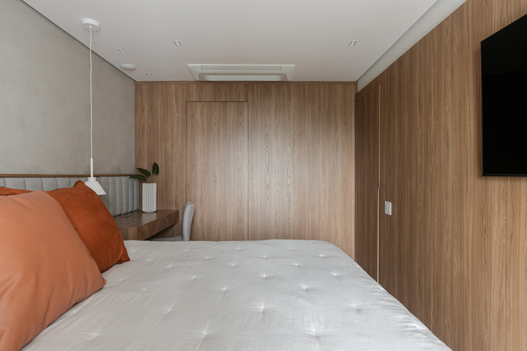 Suite com marcenaria em madeira e cabeceira estofada